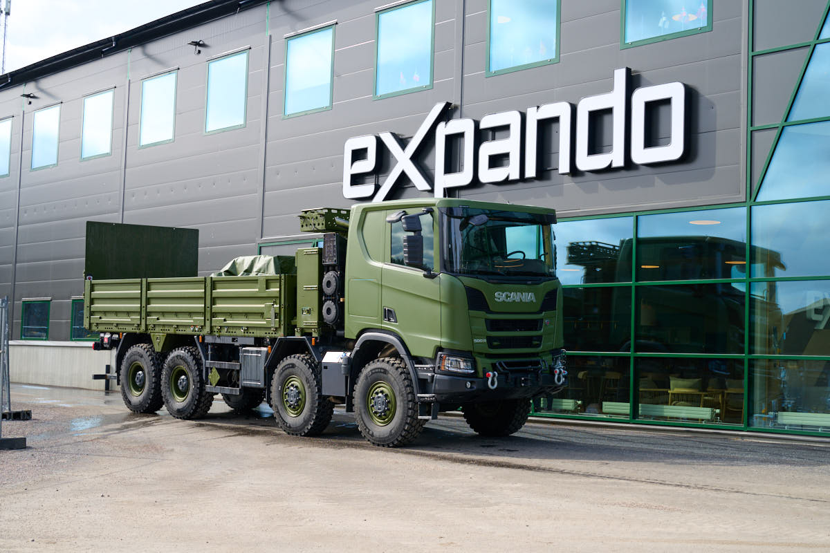 Military green truck in fron of office with Expando logo